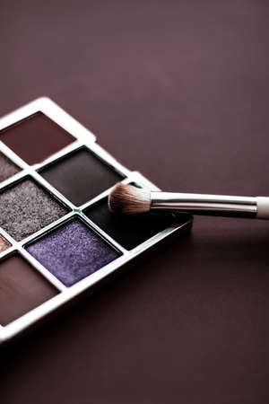 Cosmetic branding, mua and girly concept - Eyeshadow palette and make-up brush on chocolate background, eye shadows cosmetics product for luxury beauty brand promotion and holiday fashion blog designの写真素材