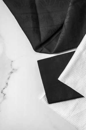 Tableware, material or cloth concept - Kitchen textile on chic white marble background, napkin and towel set, folded fabrics as food styling props for luxury home decor brand, interior designの写真素材