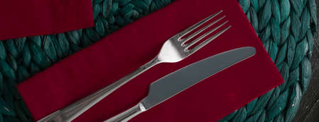 Table scape, menu and interior concept - Holiday table setting with red napkin and silver cutlery,...