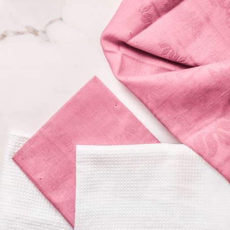 Tableware, material or cloth concept - Kitchen textile on chic white marble background, napkin and towel set, folded fabrics as food styling props for luxury home decor brand, interior designの写真素材