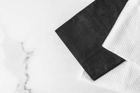Tableware, material or cloth concept - Kitchen textile on chic white marble background, napkin and towel set, folded fabrics as food styling props for luxury home decor brand, interior designの写真素材