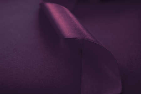 Branding, holidays and luxe brands concept - Abstract curly silk ribbon on purple background,...