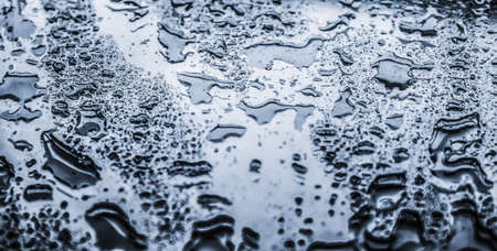 Liquid, wet and zen concept - Water texture abstract background, aqua drops on silver glass as science macro element, rainy weather and nature surface art backdrop for environmental brand designの写真素材