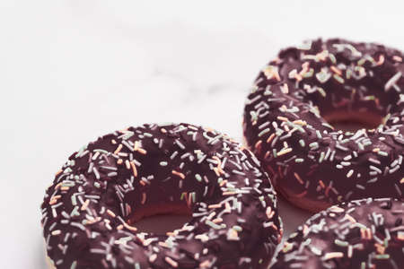 Bakery, branding and cafe concept - Frosted sprinkled donuts, sweet pastry dessert on marble table background, doughnuts as tasty snack, top view food brand flat lay for blog, menu or cookbook designの写真素材