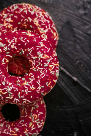 Bakery, branding and cafe concept - Frosted sprinkled donuts, sweet pastry dessert on rustic wooden...