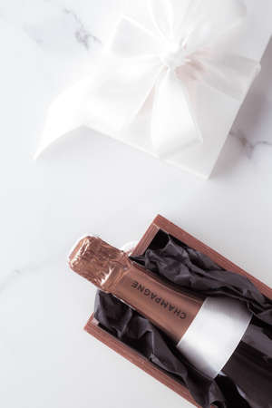 Celebration, drink and branding concept - Champagne bottle and gift box on marble, New Years,...