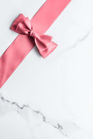 Birthday, wedding and girly branding concept - Coral silk ribbon and bow on marble background, girl baby shower present and glamour fashion gift decor for luxury beauty brand, holiday flatlay designの写真素材