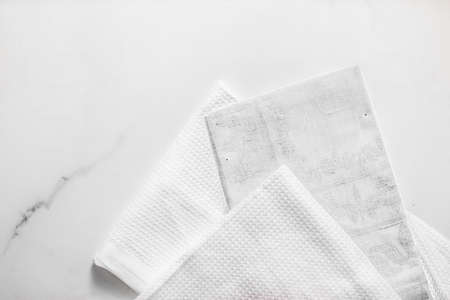Tableware, material or cloth concept - Kitchen textile on chic white marble background, napkin and towel set, folded fabrics as food styling props for luxury home decor brand, interior designの写真素材