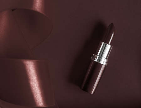 Cosmetic branding, glamour lip gloss and shopping sale concept - Luxury lipstick and silk ribbon on chocolate holiday background, make-up and cosmetics flatlay for beauty brand product designの写真素材