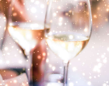 Winery, fine dining drink and luxury New Years Eve celebration concept - Winter holiday glasses of white wine and glowing snow on background, Christmas time romanceの写真素材