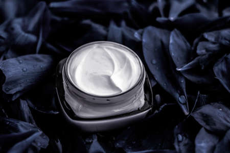 Cosmetic branding, moisturizing and anti-age - Luxury face cream moisturizer for facial skin on dark flower background, floral essense, spa cosmetics and beauty emulsion for skincare brand productの写真素材