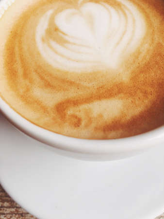 Morning drink, breakfast and rustic style concept - Cup of hot cappuccino in a cafeteria, coffee on a wooden table in cafeの写真素材