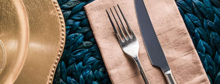 Table scape, menu and interior concept - Holiday table setting with beige napkin and silver cutlery,...