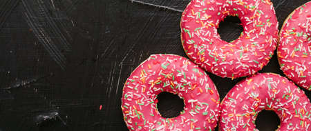 Bakery, branding and cafe concept - Frosted sprinkled donuts, sweet pastry dessert on rustic wooden...