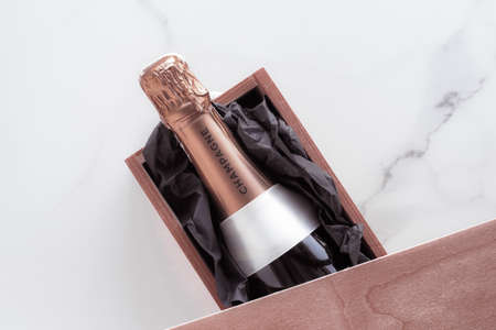 Celebration, drink and branding concept - Champagne bottle and gift box on marble, New Years, Christmas, Valentines Day or wedding holiday present and luxury product packaging for beverage brandの写真素材