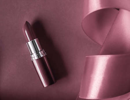 Cosmetic branding, glamour lip gloss and shopping sale concept - Luxury lipstick and silk ribbon on purple holiday background, make-up and cosmetics flatlay for beauty brand product designの写真素材