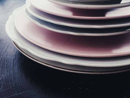 Stack of clean empty plates on black background, luxe dishware and table decorの写真素材