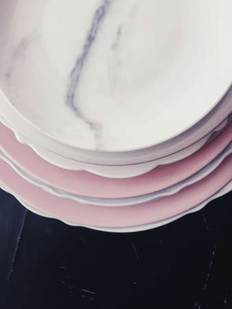 Stack of clean empty plates on black background, luxe dishware and table decorの写真素材