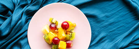 Fresh organic fruit salad on pink plate, healthy nutrition and detox diet plan, flat layの写真素材