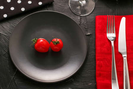 Red tomatoes on black plate, organic food and healthy diet conceptの写真素材