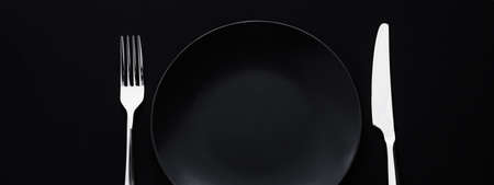 Empty plates and silverware on black background, premium tableware for holiday dinner, minimalistic design and diet conceptの写真素材