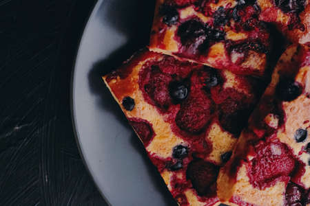 Berry pie on black plate, rustic homemade food with organic ingredients on black backgroundの写真素材
