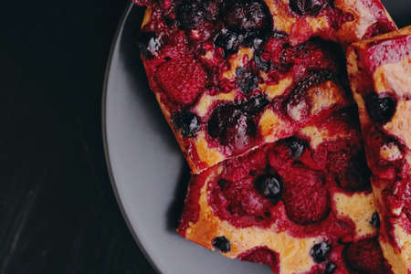 Berry pie on black plate, rustic homemade food with organic ingredients on black backgroundの写真素材