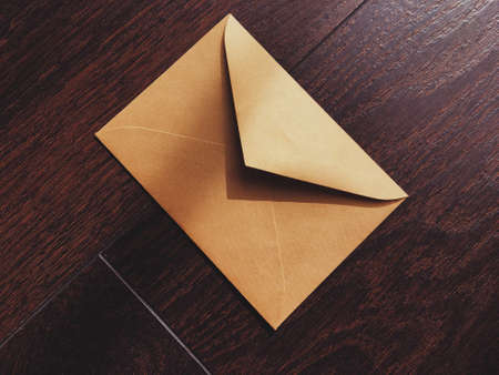 Golden vintage envelope on wooden background, newsletter and message conceptの写真素材