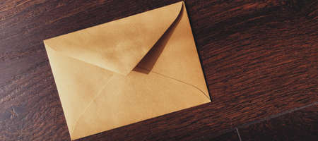 Golden vintage envelope on wooden background, newsletter and message conceptの写真素材