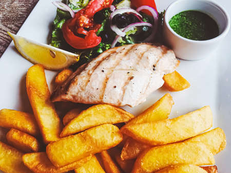 Grilled chicken, french fries and salad for lunch, served mealの写真素材