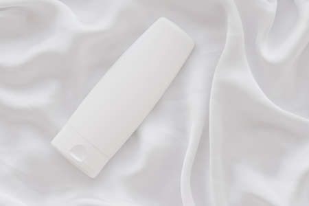 Blank label cosmetic container bottle as product mockup on white silk background, hygiene and...