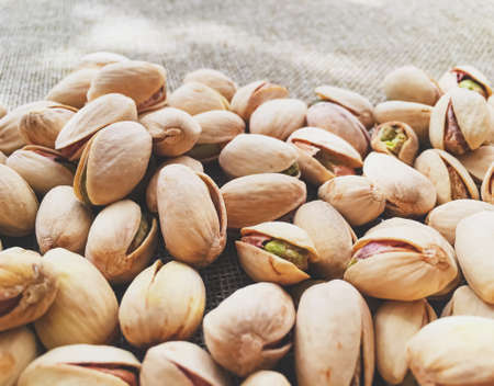 Pistachio nuts on rustic linen background, food and nutritionの写真素材
