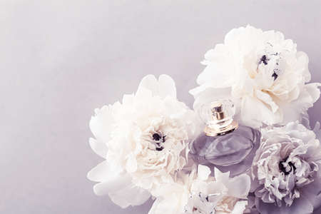 Violet fragrance bottle as luxury perfume product on background of peony flowers, parfum ad and beauty branding designの写真素材