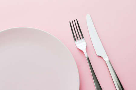 Empty plate and cutlery as mockup set on pink background, top tableware for chef table decor and menu branding designの写真素材