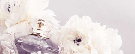 Violet fragrance bottle as luxury perfume product on background of peony flowers, parfum ad and...