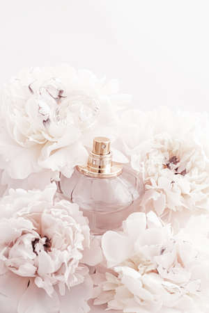 Fragrance bottle as luxury perfume product on background of peony flowers, parfum ad and beauty...