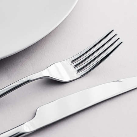 Empty plate and cutlery as mockup set on white background, top tableware for chef table decor and...