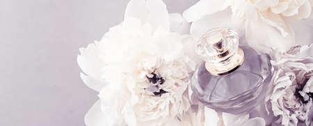 Violet fragrance bottle as luxury perfume product on background of peony flowers, parfum ad and...