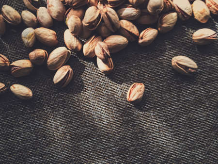 Pistachio nuts on rustic linen background, food and nutritionの写真素材