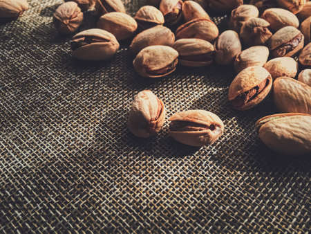 Pistachio nuts on rustic linen background, food and nutritionの写真素材