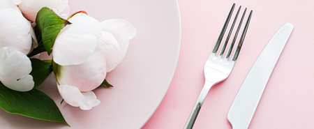 Dining plate and cutlery with peony flowers as wedding decor set on pink background, top tableware for event decoration and menu branding designの写真素材