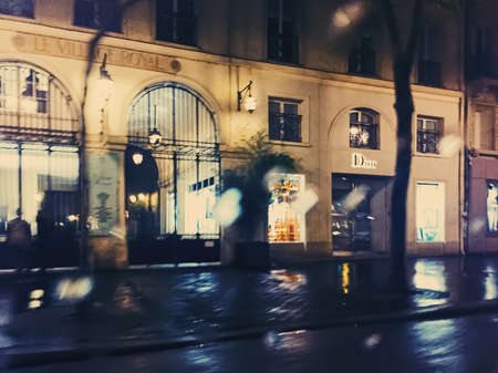 Paris, France circa January, 2020: Historical buildings, restaurants and boutique stores on streets of Paris, France at nightのeditorial素材