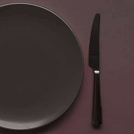 Empty plate and cutlery as mockup set on dark brown background, top tableware for chef table decor and menu branding designの写真素材