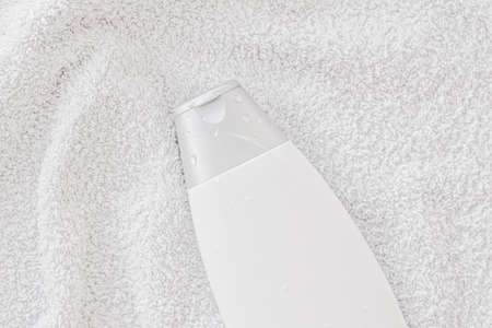 Blank label cosmetic container bottle as product mockup on white towel background, hygiene and...