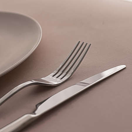 Empty plate and cutlery as mockup set on brown background, top tableware for chef table decor and...