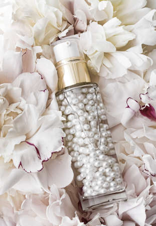 Luxurious cosmetic bottle as antiaging skincare product on background of flowers, blank label packaging for body care branding designの写真素材