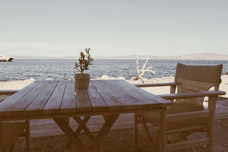 Empty restaurant by the Aegean sea and cruise boat, travel and nature, sceneの写真素材