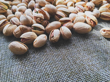 Pistachio nuts on rustic linen background, food and nutritionの写真素材