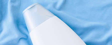 Blank label shampoo bottle or shower gel mockup on blue silk background, beauty product and body...