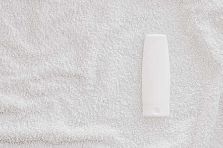 Blank label cosmetic container bottle as product mockup on white towel background, hygiene and healthcareの写真素材